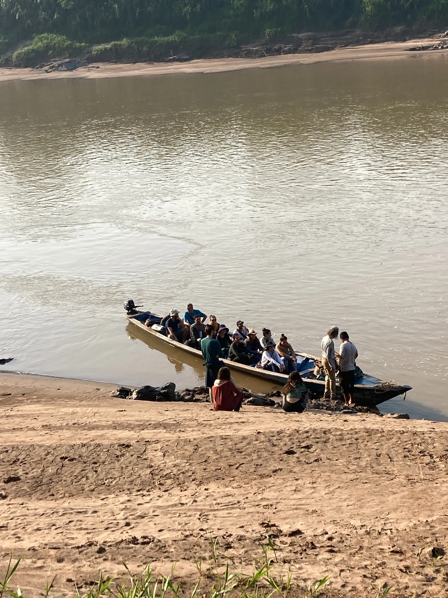 Participants arriving by long wooden boat on the Amazon River