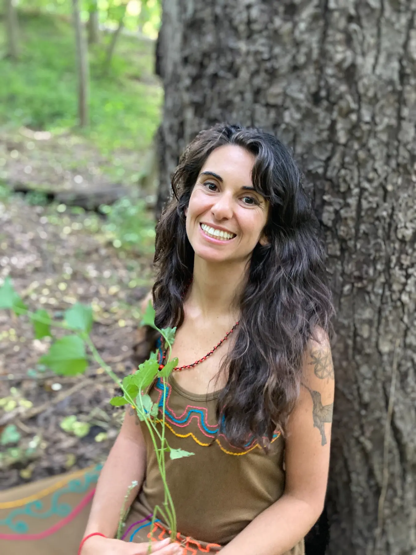 Sofia smiling beside a large tree