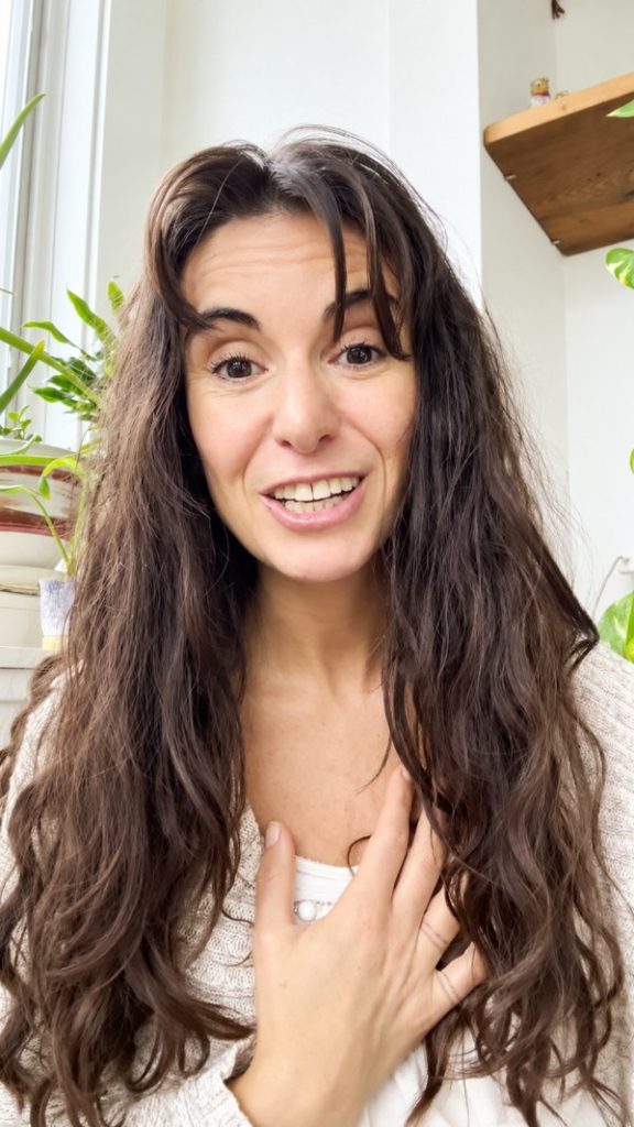 Sofia Zilberman smiling with her hand on her heart in her relationship and connection video