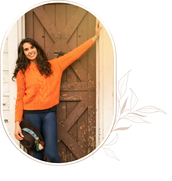 Sofia smiling in an orange sweater with her drum